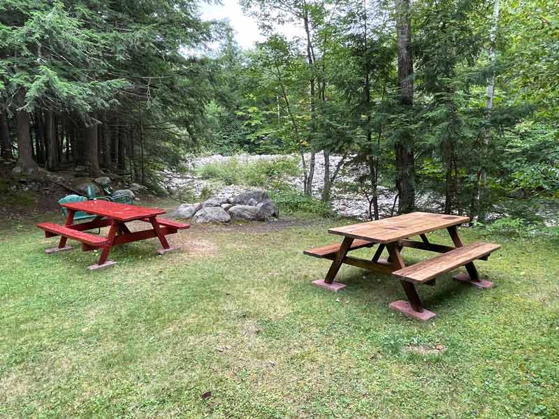 picnic tables beside stream